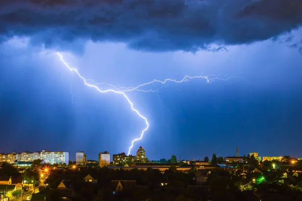 Błyskawica nad miastem na nocnym niebie uderza na dachu domu — Zdjęcie stockowe