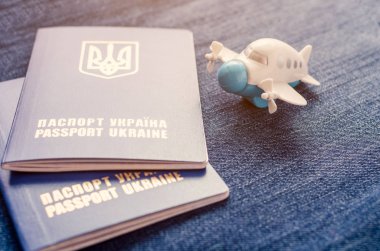 Bir küçük oyuncak uçak ve iki Ukrayna pasaportları mavi