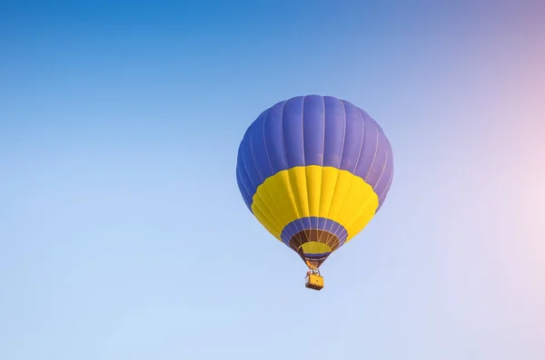 Colorido de balão de ar quente com fundo de fogo e céu azul — Fotografia de Stock