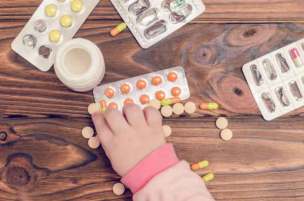 나무 테이블에 약으로 어린이 손. 작은 아이 왼쪽 무인된 연극 위험한 마약 — 스톡 사진