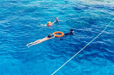 Sharm El Sheikh, Mısır, 8 Mayıs 2019: Şnorkelle yüzen insanlar açık mavi denizde yüzüyorlar