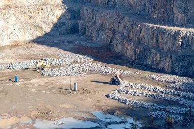 Kazıcı ve ağır maden kamyonu granit ocağında.