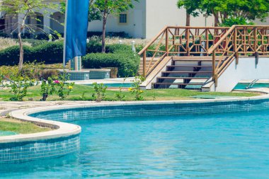 Güneşli bir günde berrak suyla açık deniz yüzme havuzu