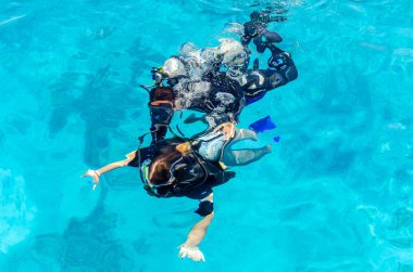Scuba dalgıçlar denizde berrak mavi suya dalış