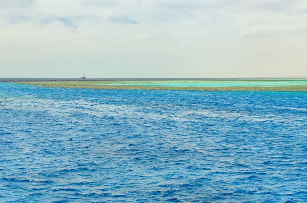 Increspature colorate della superficie dell'acqua nel Mar Rosso con vista sul corallo sul fondo — Foto Stock