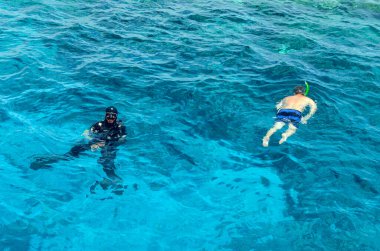 Sharm El Sheikh, Mısır, 8 Mayıs 2019: Şnorkelle yüzen insanlar açık mavi denizde yüzüyorlar