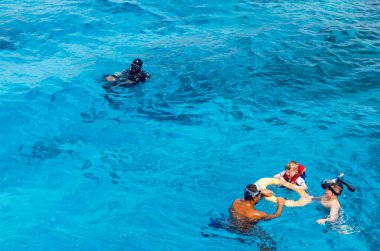 Sharm El Sheikh, Mısır, 8 Mayıs 2019: Şnorkelle yüzen insanlar açık mavi denizde yüzüyorlar