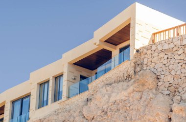 Mavi gökyüzüne karşı kayalık bir sahilde daireler