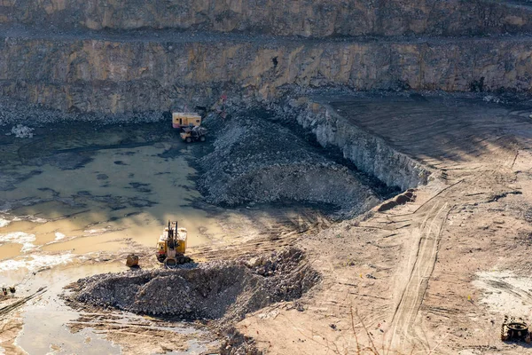 Excavadora y camión minero pesado en una cantera de granito — Foto de Stock