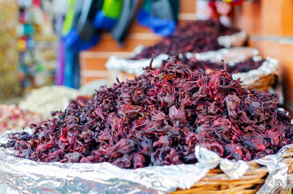 Hojas secas de té de hibisco en una canasta de mimbre en un mercado callejero —  Fotos de Stock