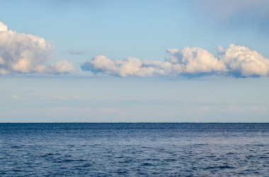 Deniz manzarası, bulutlu mavi gökyüzü ve deniz suyu.