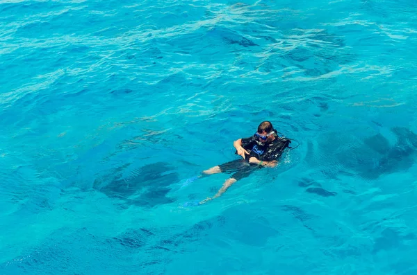 Sharm El Sheikh, Egipto, 8 de mayo de 2019: Un hombre en equipo de buceo nada en el agua azul clara del mar — Foto de Stock