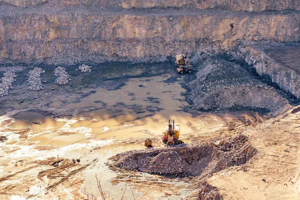 Grävmaskin och tung gruvlastbil i ett granitbrott — Stockfoto