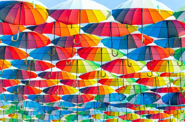 Colgando paraguas multicolores coloridos adornan el callejón, decoración de la calle — Foto de Stock