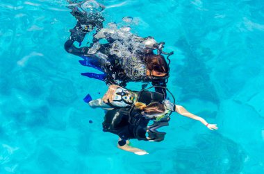 Scuba dalgıçlar denizde berrak mavi suya dalış