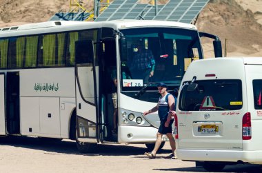 Dahab, Mısır 11 Mayıs 2019: Otoparktaki gezi otobüsünün yanındaki turist