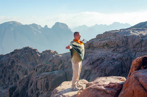 Sinai-félsziget, Egyiptom, 2019. május 9.: Egy férfi széles karokkal pózol a hegyekben — Stock Fotó