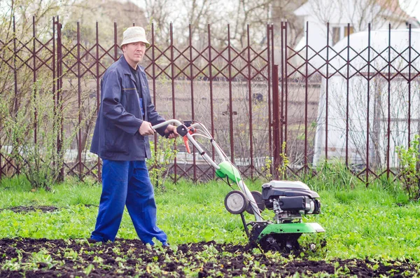 Een Man Cultiveert Het Land Met Een Cultivator Een Lentetuin — Stockfoto