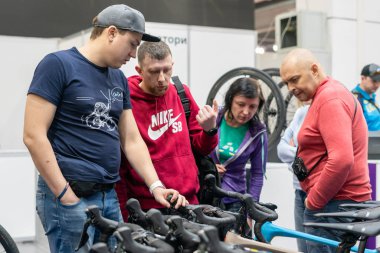 Kyiv, Ukraine, February 28, 2020: bike Expo 2020, the seller stands near the bikes showing them to customers