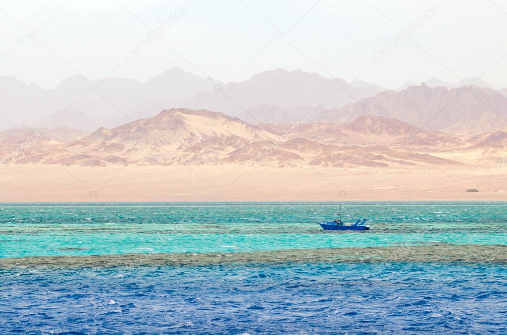 A small boat against the background of mountains and the sea in Ras Mohammed National Park, Egypt.