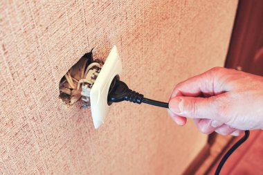 El fişi koparıp elektrik şoku riski olan kırık bir prize bağlar..