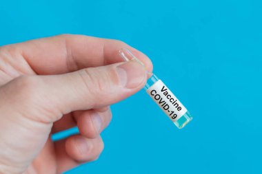 Mavi arka planda covid-19 koronavirüs aşısı var..