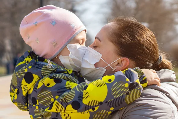 Jovem Mãe Beija Sua Filha Através Máscaras Médicas Protetoras Covid — Fotografia de Stock