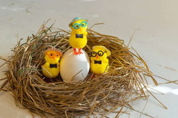 Yellow toy chickens and eggs in the nest.