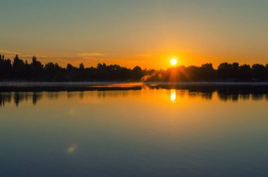 Gölde şafak söker, ağaçlardan güneş çıkar..