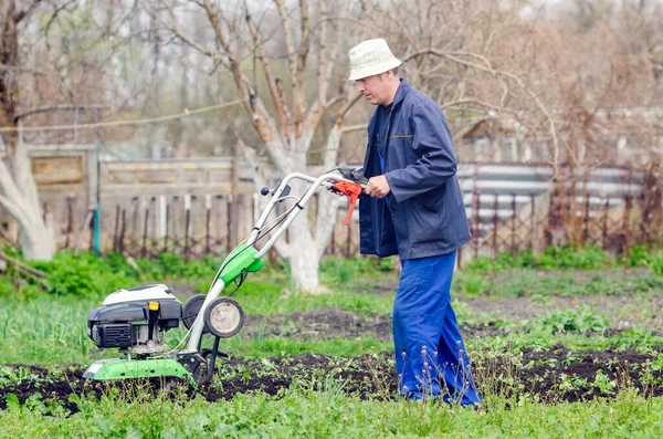 Een Man Ploegt Het Land Met Een Cultivator Een Lentetuin — Stockfoto