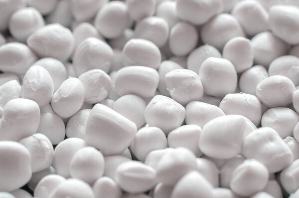 Белый полимерный краситель в гранулах, текстура фона.