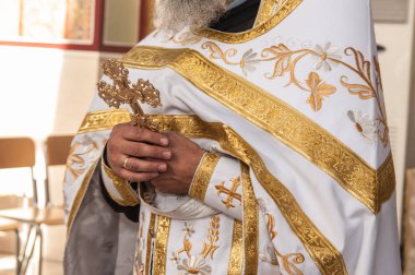 Rahip bir haç tutar