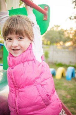 Sevimli küçük kız sitthing Bahçesi Slayt üzerindeki.