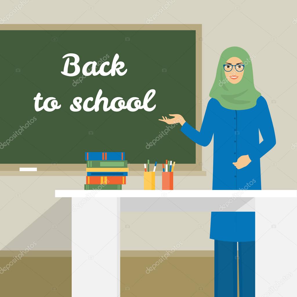 Arab woman stands near the board. The teacher in the classroom at the table.