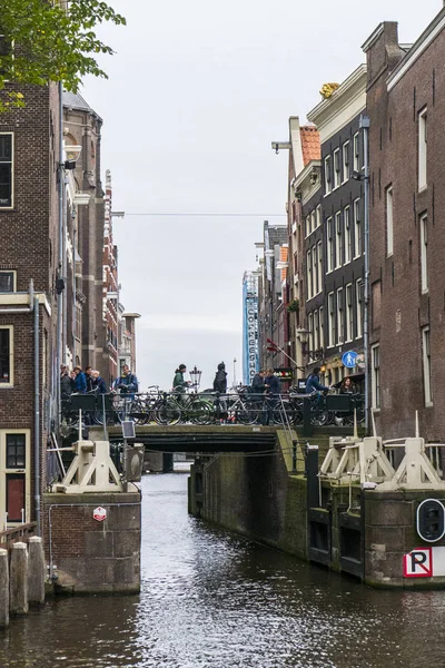 Pessoas em Amsterdam bycicles estacionamento — Fotografia de Stock