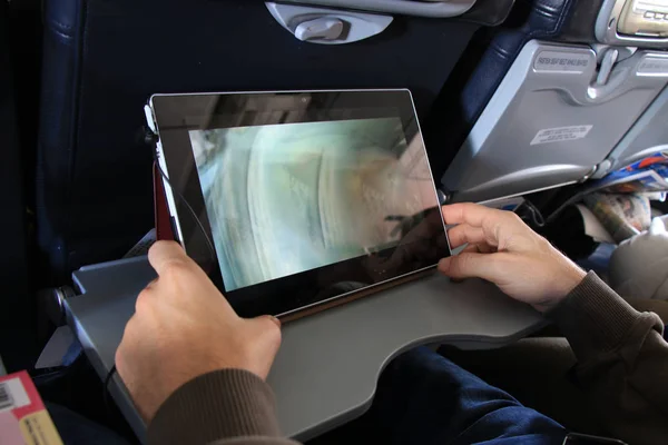Der Passagier entspannt sich mit Tabletten im Flugzeug — Stockbild Der Passagier mit Tablet — Stockfoto