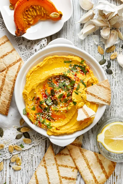 Hummus de abóbora assada, molho cremoso e delicioso em um prato branco — Fotografia de Stock