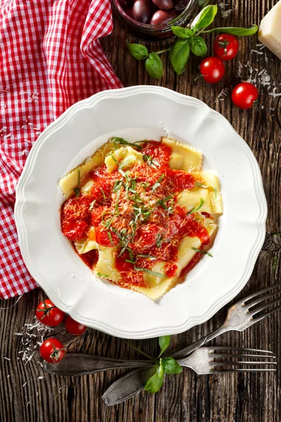 Ravioli rellenos de verduras a la parrilla cubierto con salsa de tomate, queso de grana padano y la albahaca fresca, vista superior — Foto de Stock