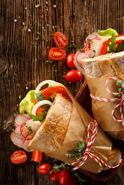 Бутерброд зі свіжими овочами та копченою шинкою на дерев'яному столі — стокове фото