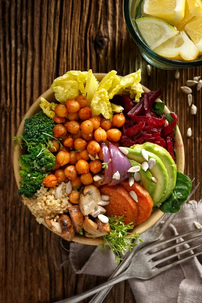 Gezonde salade met een verscheidenheid aan groenten, broccoli, zoete aardappelen, kikkererwten, bieten, avocado's met de toevoeging van cashewnoten en zonnebloempitten — Stockfoto