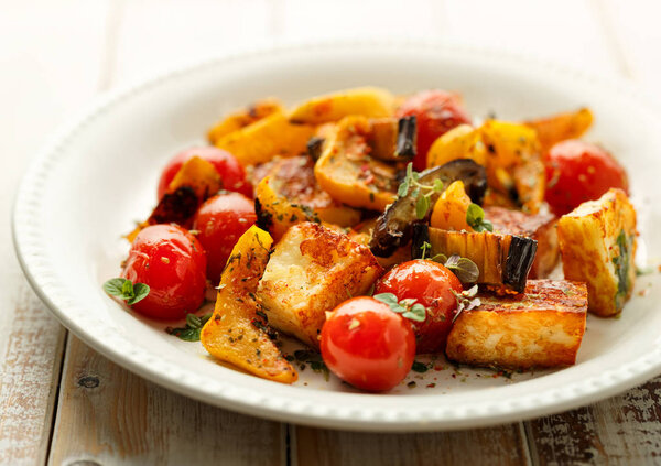 Salad with grilled halloumi cheese and vegetable with addition of aromtic herbs