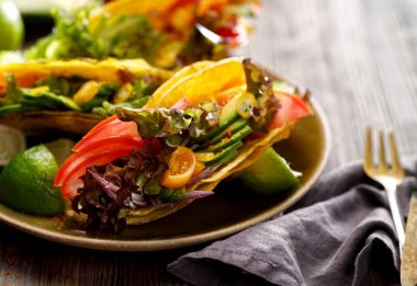 Corn tortilla tacos with avocado, tomatoes, onion and lettuce clipart
