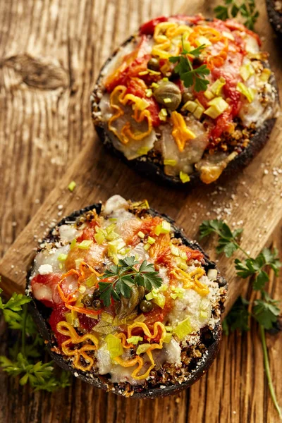 Funghi al forno al portobello ripieni di quinoa, verdure e formaggio con erbe aromatiche su una tavola di legno, cibo vegetariano — Foto Stock