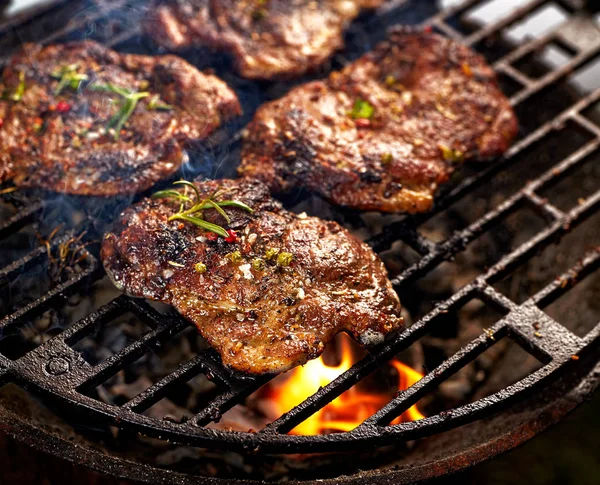 Grilované vepřové krk zaoblení steaky na grilu deska — Stock fotografie