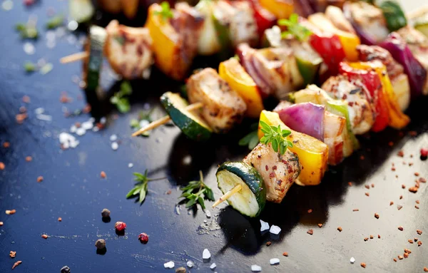 Gegrilde brochettes van vlees en groenten op een donkere achtergrond — Stockfoto