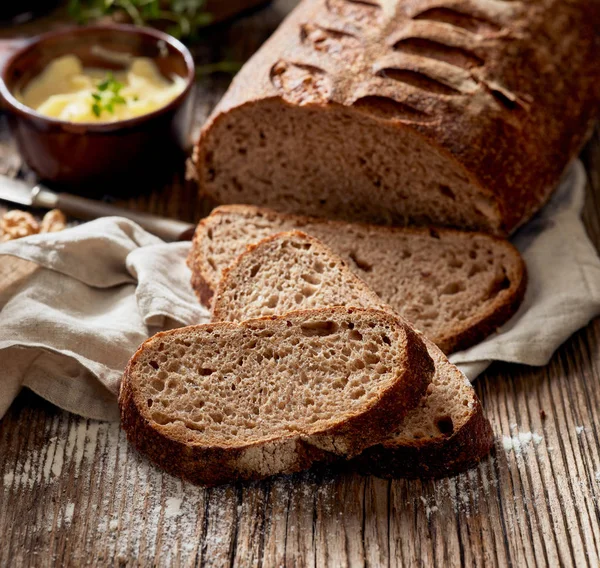 Kromki chleba zakwas rustykalne na drewnianym stole — Zdjęcie stockowe