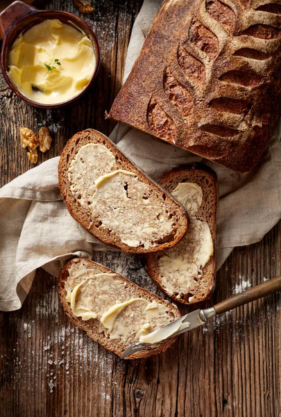 Kromki chleba zakwas rustykalny z domu masło na drewnianym stole — Zdjęcie stockowe