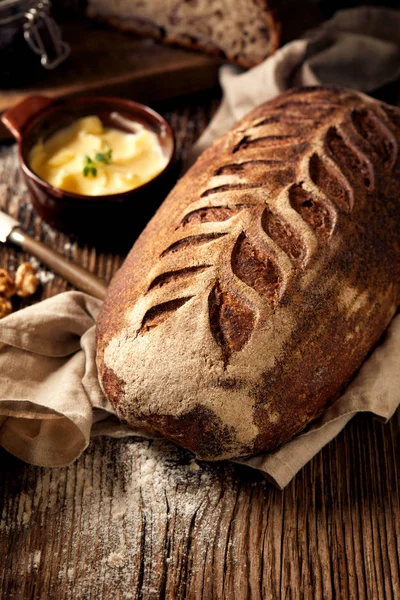 Rustykalne zakwasie chleb na drewnianym stole — Zdjęcie stockowe