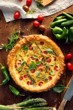 Quiche kiraz domates ve rustik ahşap bir masa, üstünde yeşil kuşkonmaz ile ana sayfa görünümü