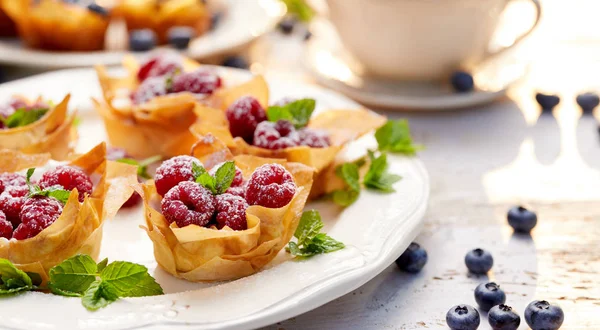 Filobecher mit Frischkäsefüllung belegt mit frischen Himbeeren und Minze, köstliches Dessert — Stockfoto